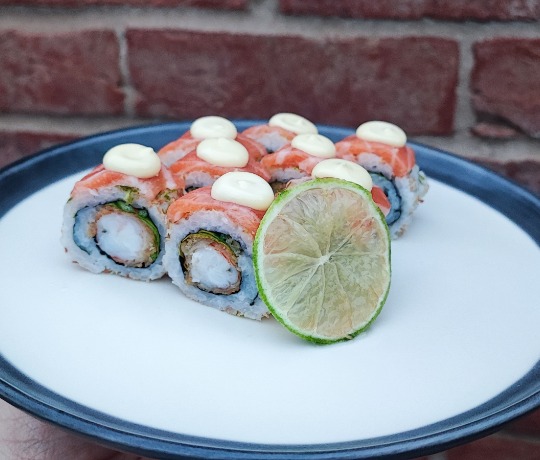 Weekly Premium: Shima Lime Roll A plate with our weekly premium roll, the Shima Lime Roll, featuring coconut, lime, salmon, and prawn.
